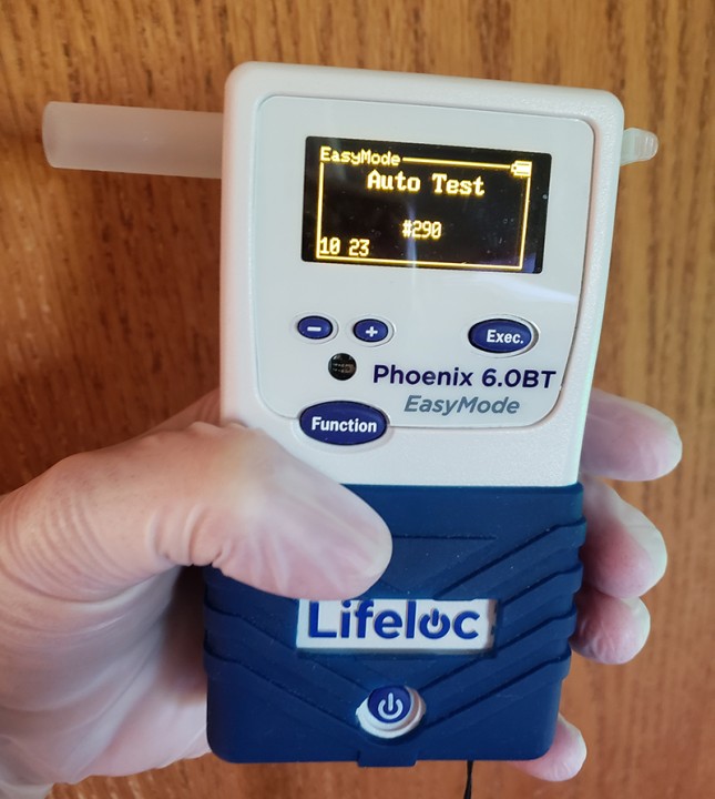 Employee Holding a Breath Alcohol Tester